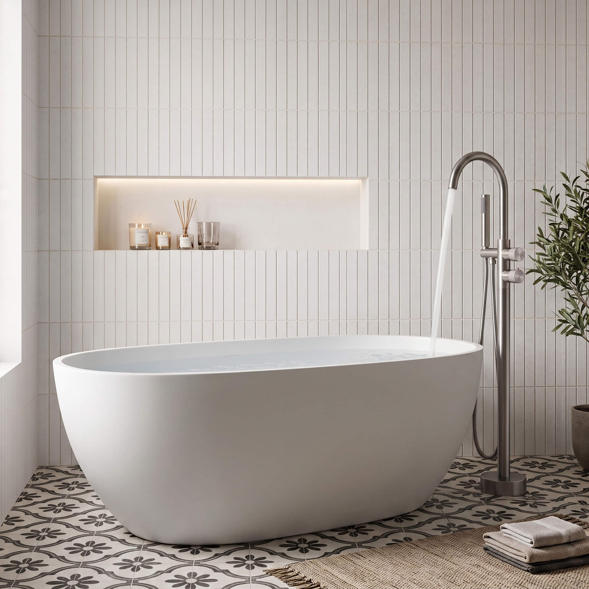 Brushed nickel freestanding tub faucet filling a modern white soaking tub
