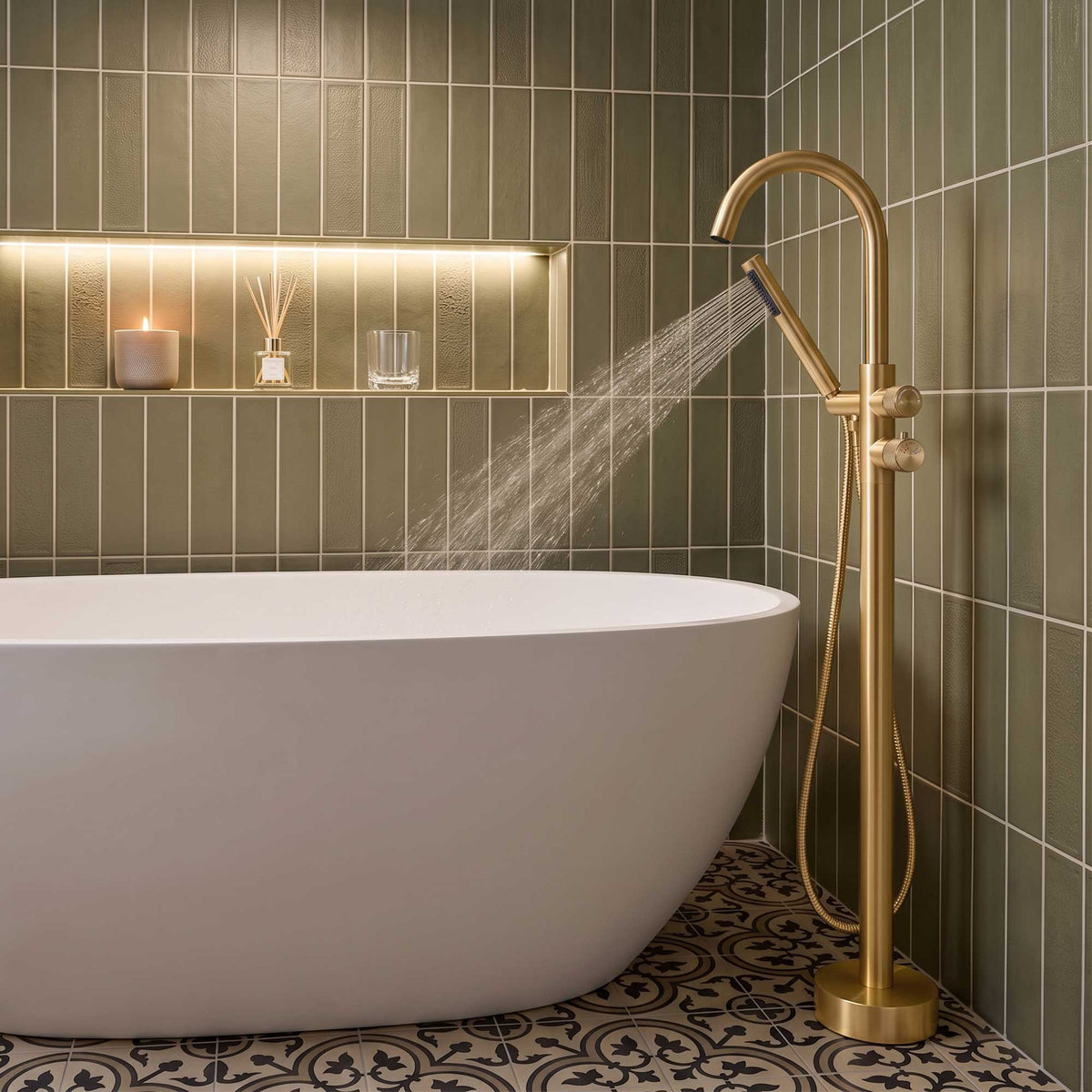Brushed gold floor mounted tub filler with handheld shower in use beside a freestanding tub
