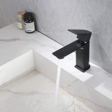 Single-hole matte black bathroom faucet with running water over vanity sink