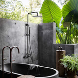 Modern outdoor bathroom with matte black rainfall shower system and handheld sprayer